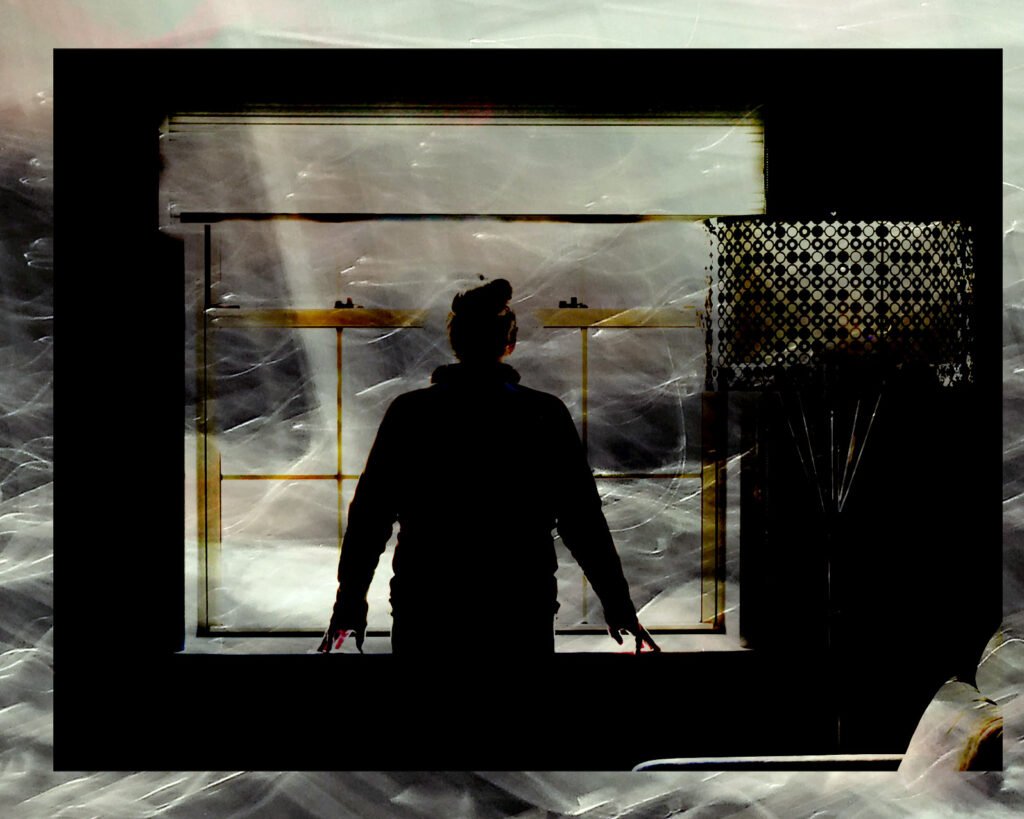 A person looking out from a window to a gray formless, turbulant scene.